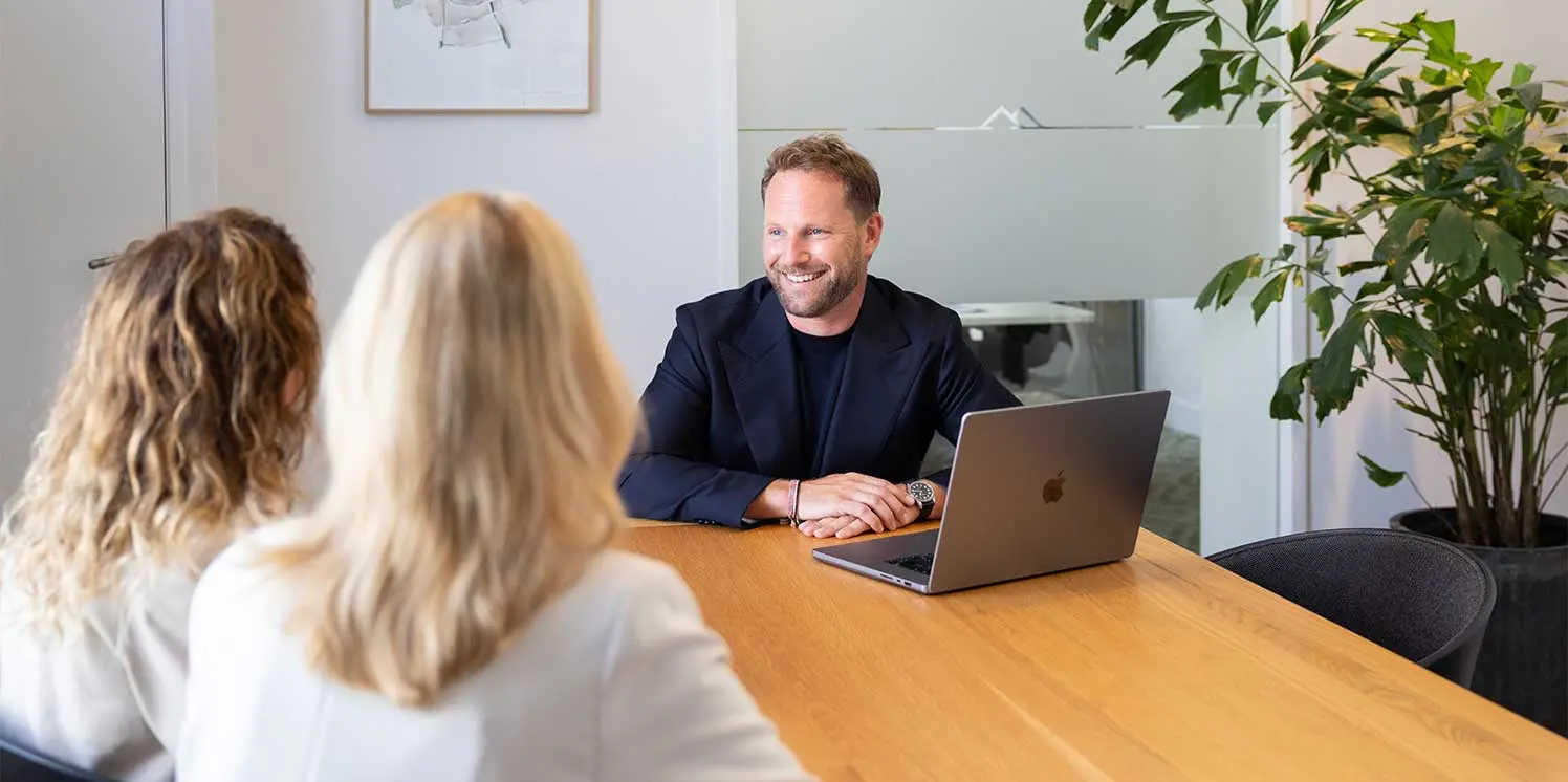 NVM-makelaar Maarten Bos van Mooijekind Vleut in gesprek met twee klanten.