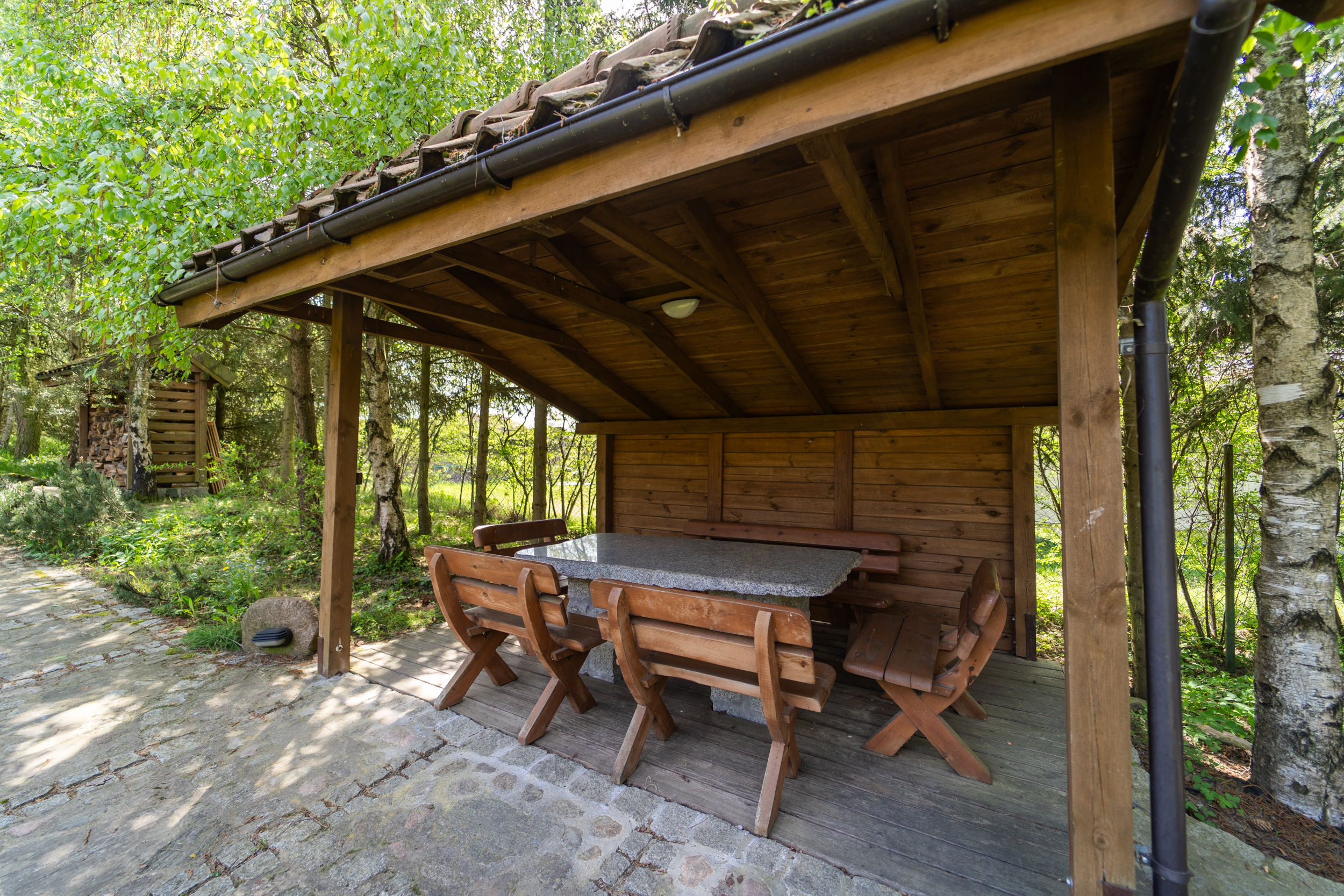 Dom Łabędź - wiata z miejscami do siedzenia przy grillu i kuchni letniej