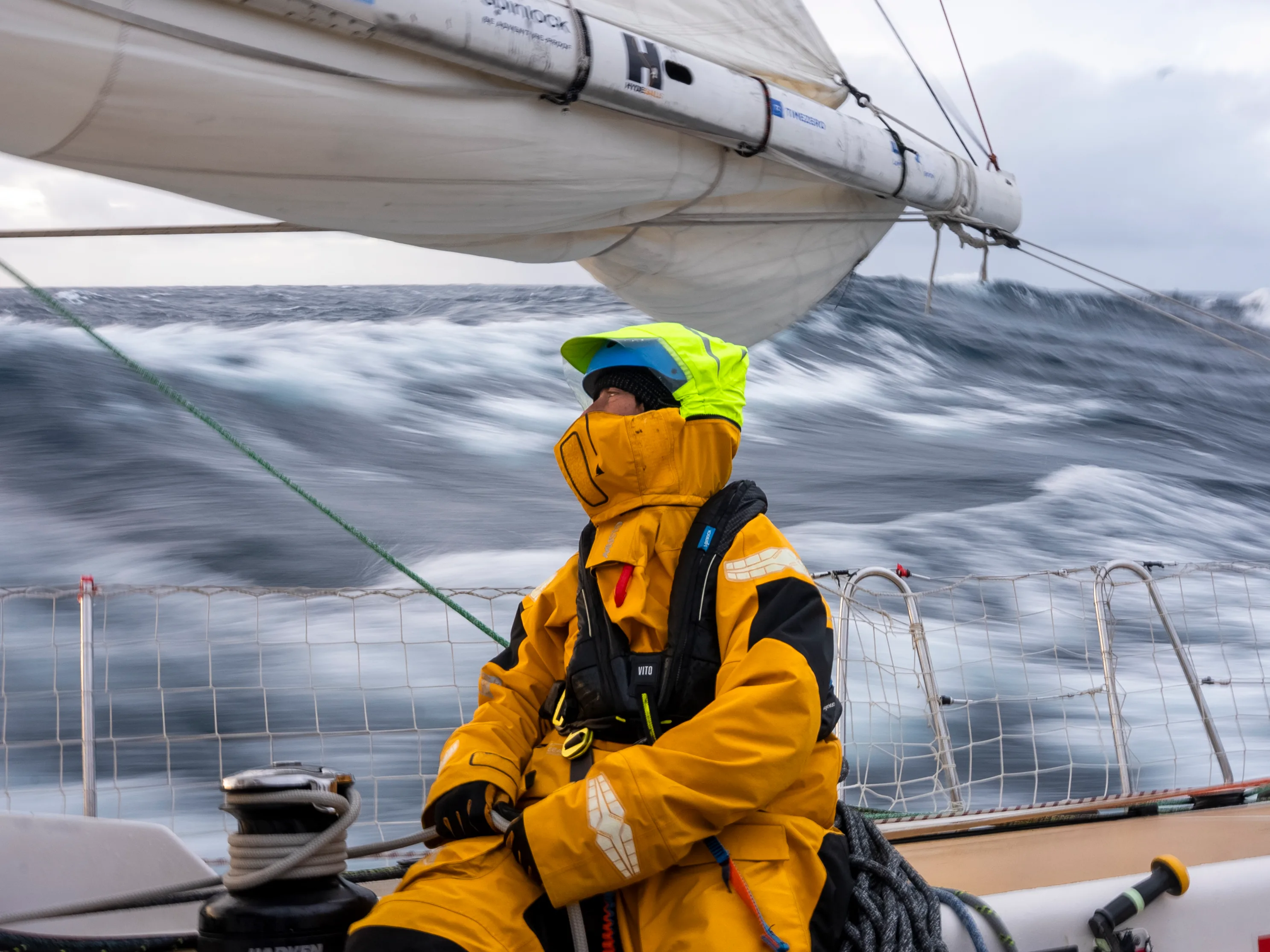 A Clipper Race crew member faces powerful Pacific swells during Leg 6, The Mighty Pacific, showcasing the challenge of offshore ocean racing.