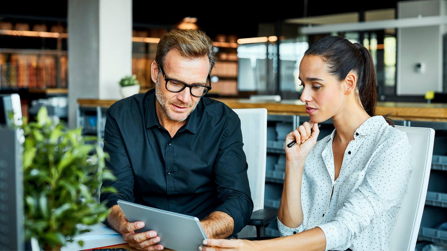 Kvinde og mand på et kontor med en iPad