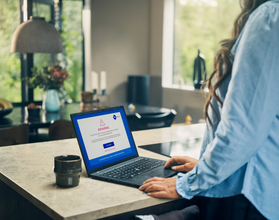 Person arbejder ved et bord. Ser advarselsskærmen fra InternetFilter - TDC Erhverv