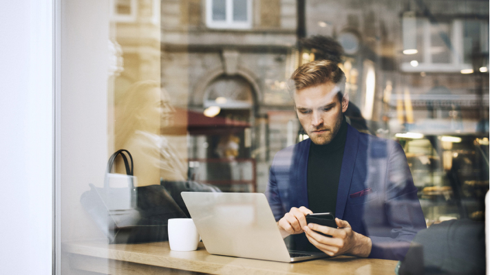 Mand sidder på café og skriver en sms