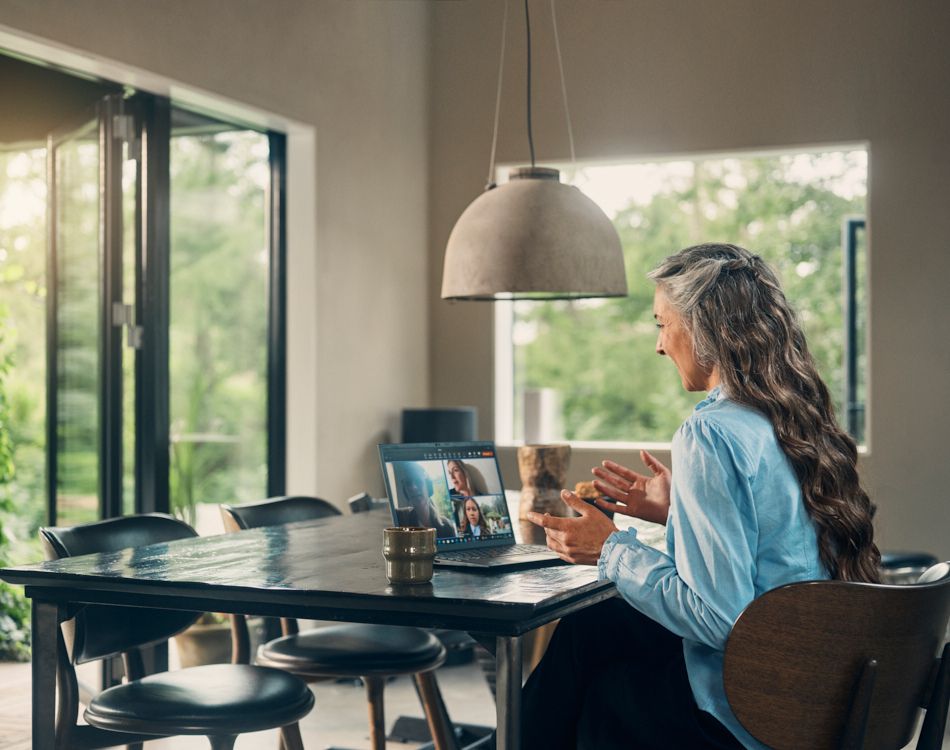 Kvinde holder online møde ved et spisebord