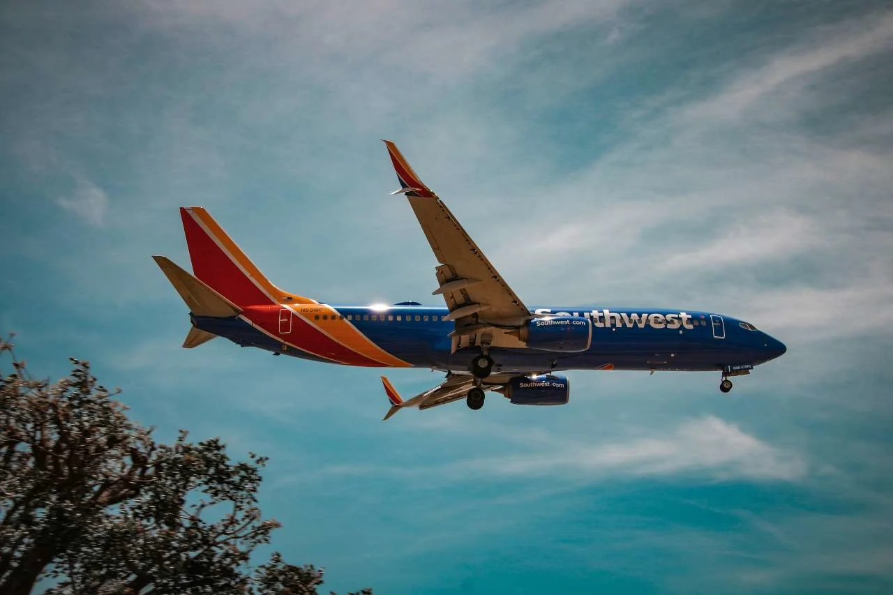 A Southwest aircraft paired with an Amex card, illustrating how to use Amex points for Southwest flights.