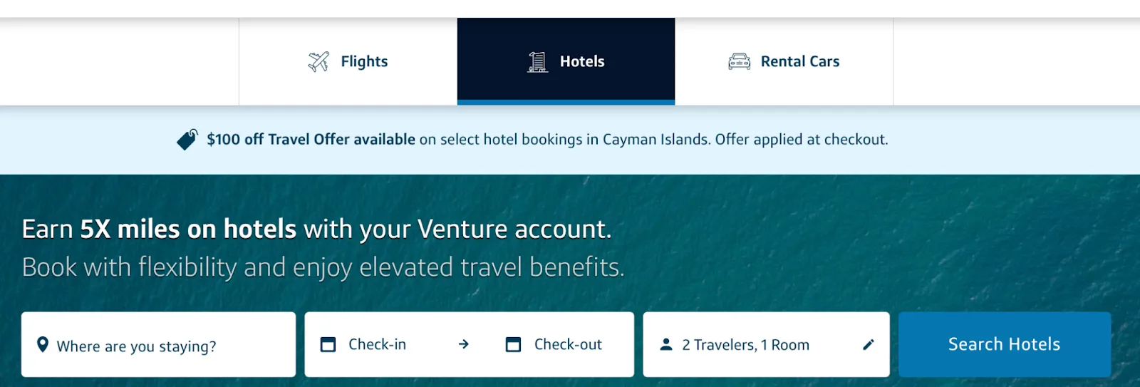 Screenshot of the Capital One Travel homepage on the Hotels tab with a search bar and a $100 off Cayman Islands offer