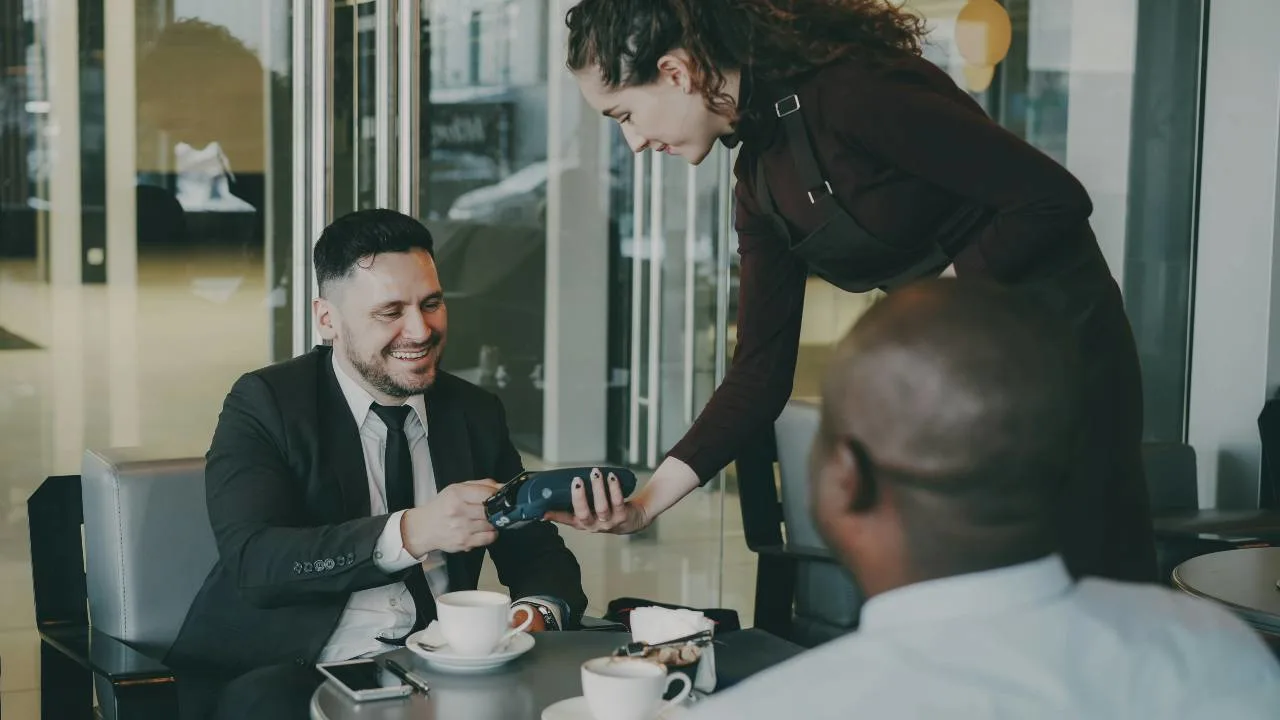 A traveler paying with a credit card abroad, illustrating the best cards with no foreign transaction fees.