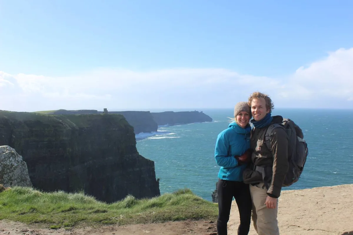A couple traveling abroad with duffel bags, illustrating a 17-month honeymoon funded by points.