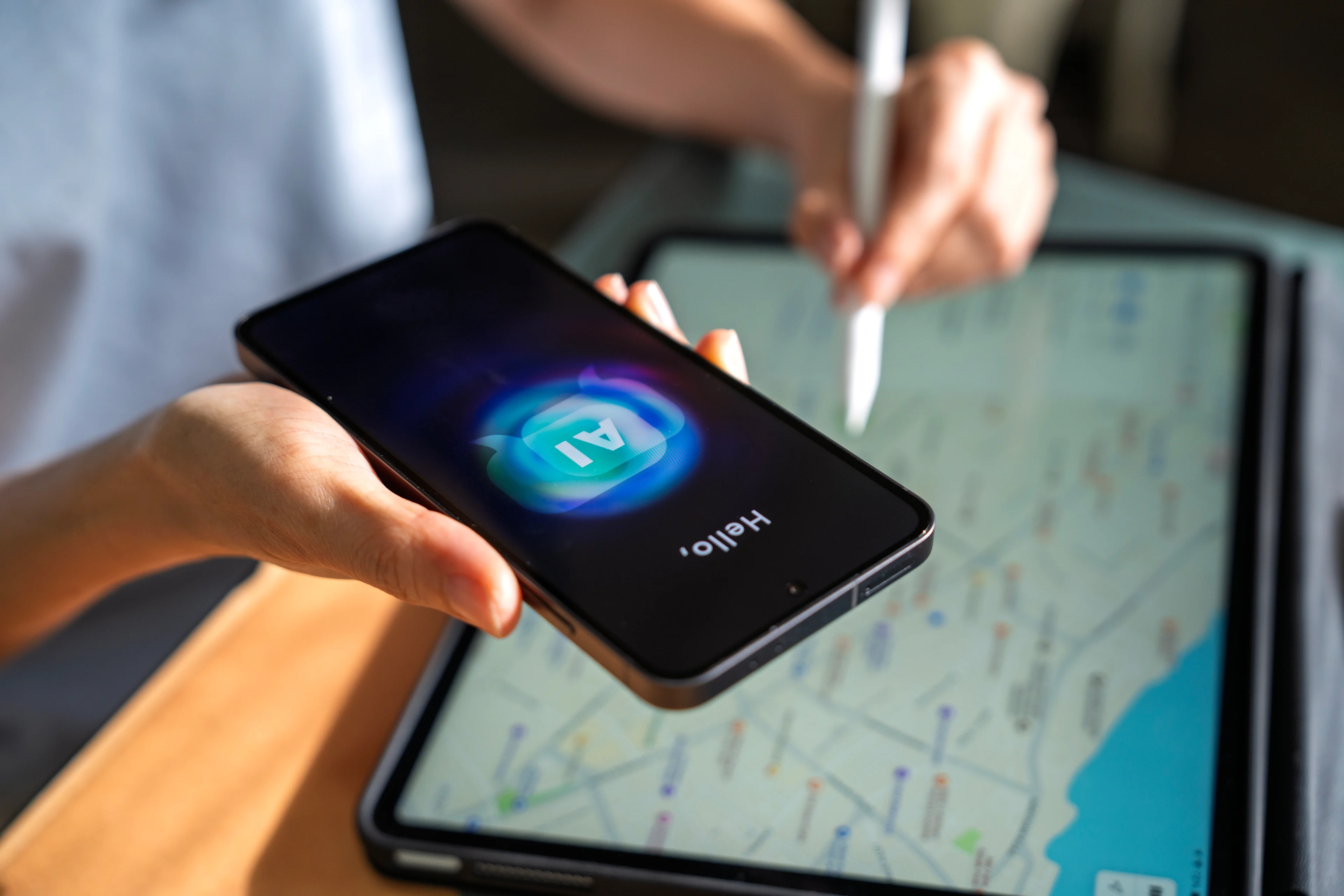 A person holding a smartphone displaying an AI assistant screen above a tablet showing a city map, used for trip planning