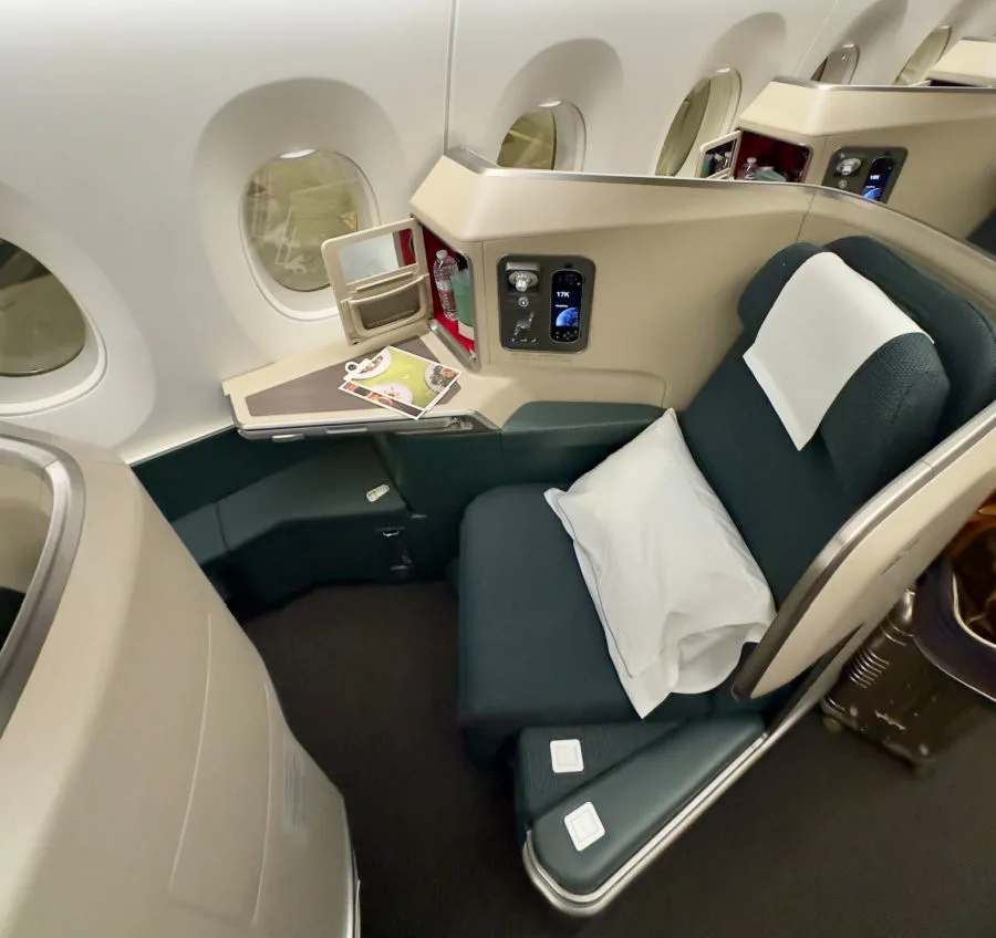A Cathay Pacific business class seat and lounge, illustrating how to fly Cathay Pacific business class for fewer points.