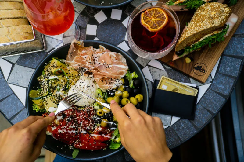 A restaurant meal paid for with a rewards credit card, illustrating the best dining and grocery cards for foodies.