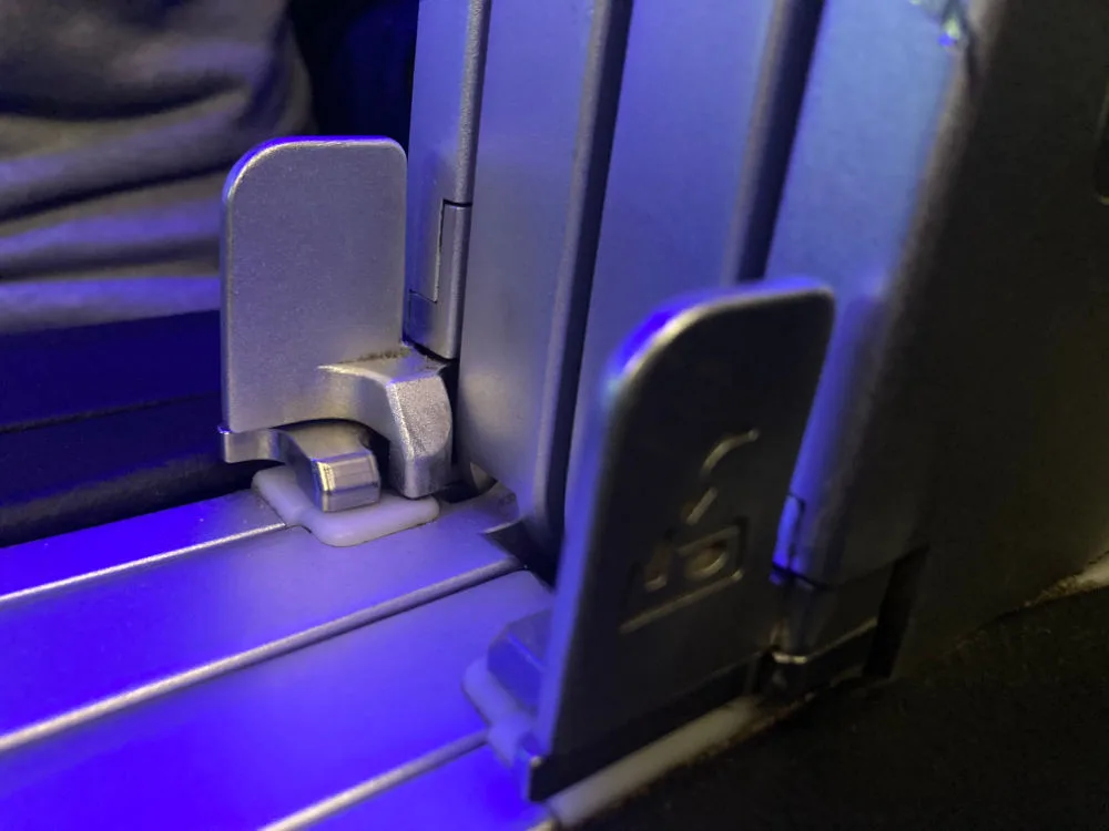 Close-up of the tray table release latch on a JetBlue Mint A321 seat