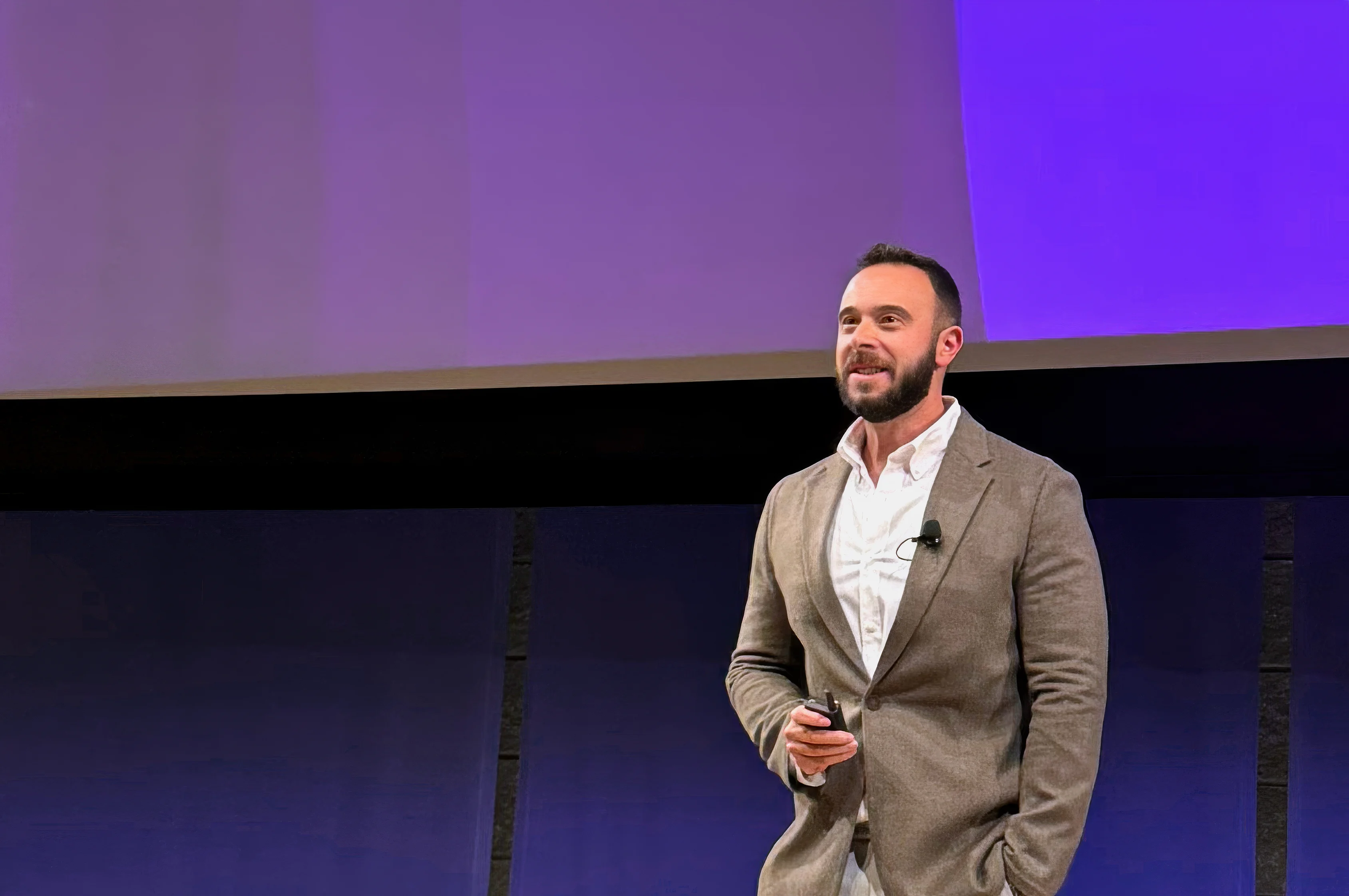 A photo of point.me CEO & Founder, Adam Morvitz, speaking on stage with a forward-looking vision
