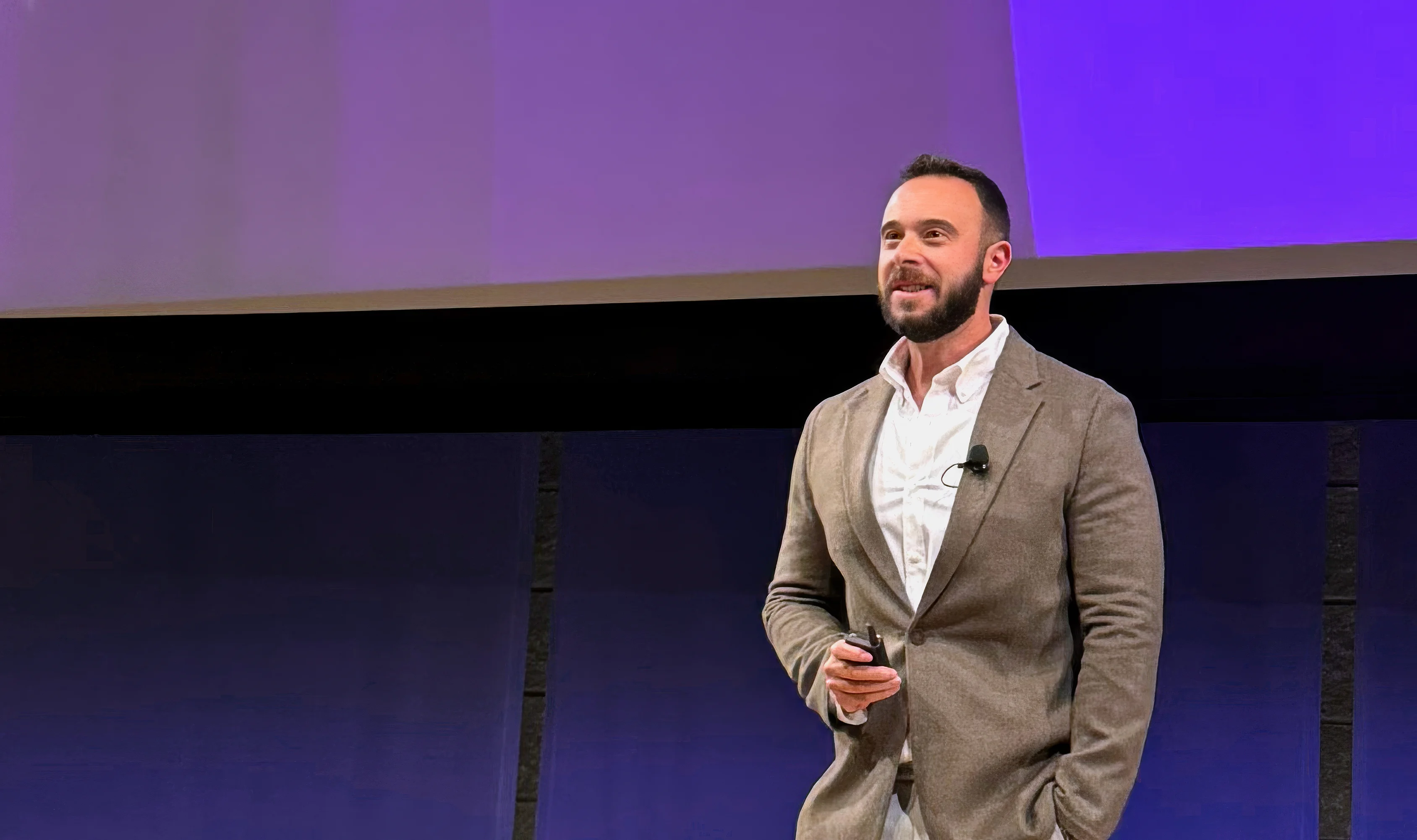 A photo of point.me CEO & Founder, Adam Morvitz, speaking on stage with a forward-looking vision