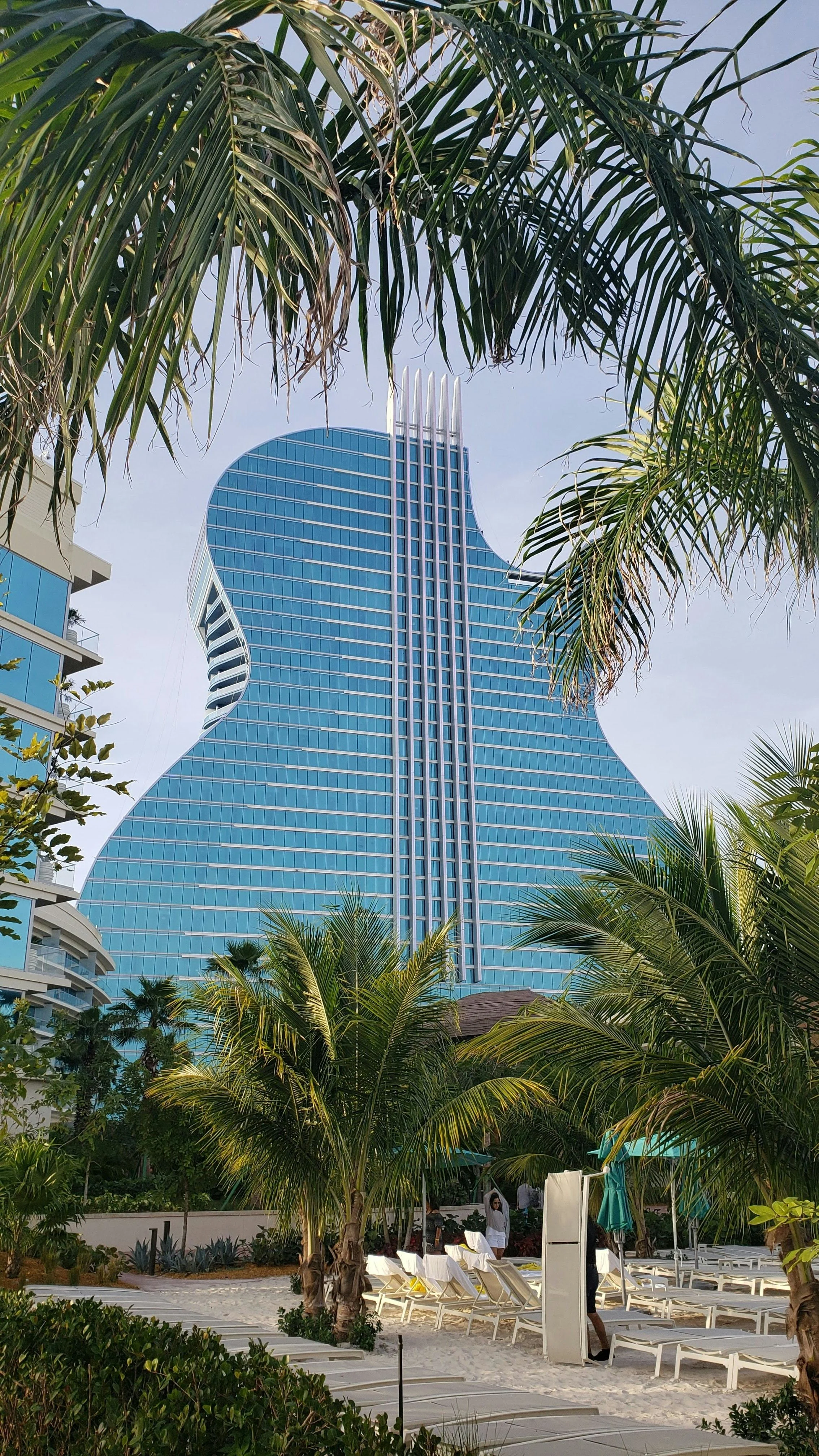 Guitar-shaped hotel tower viewed through palm trees at a Florida beach resort