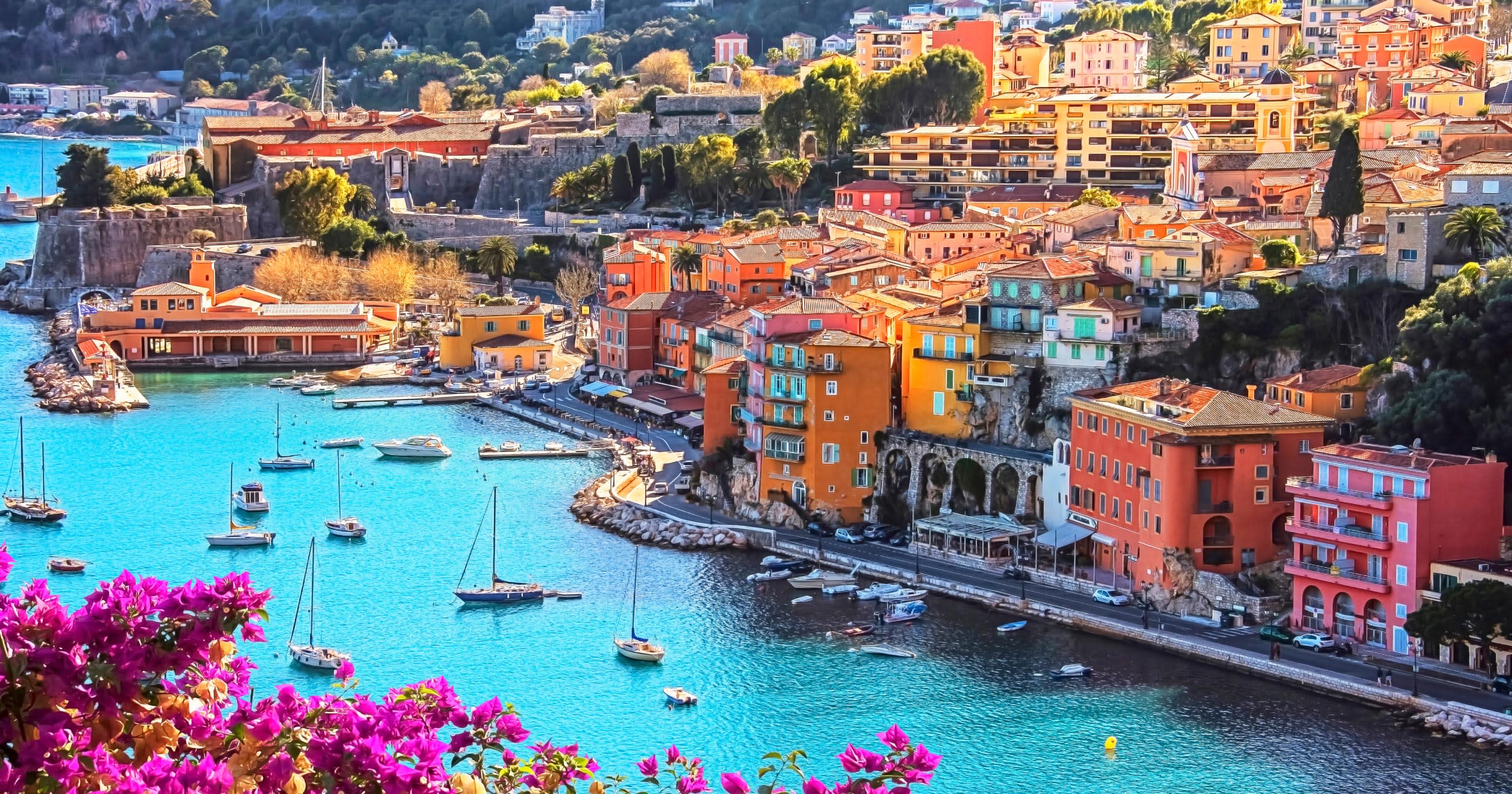 Aerial view of a colorful Nice harbor on the French Riviera with sailboats and bougainvillea — one of the international destinations bookable on points from 25 US airports.