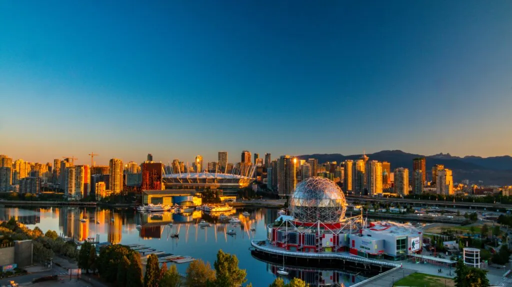 Aerial sunset view of the Vancouver skyline and waterfront, including BC Place stadium and the Telus World of Science dome