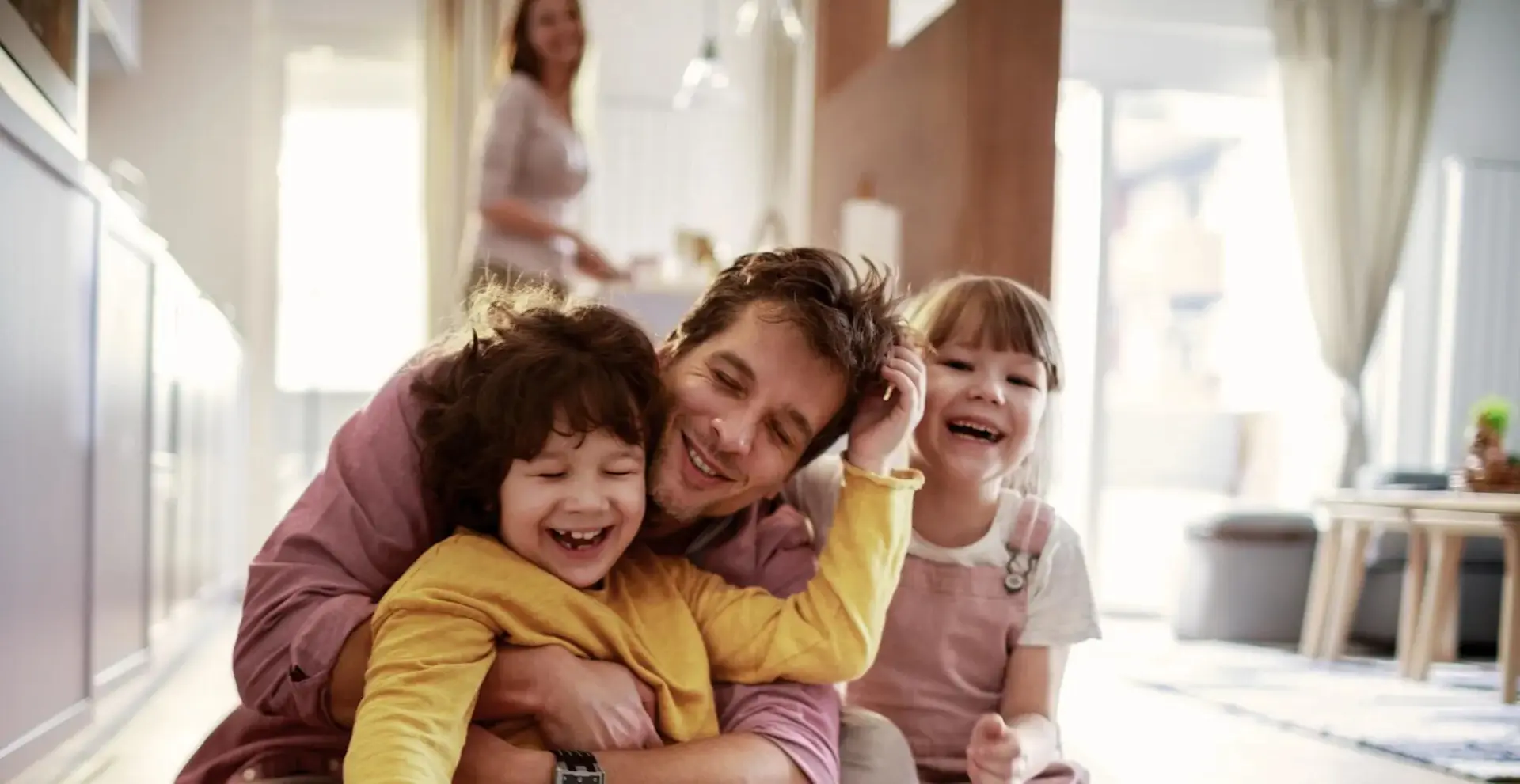 pai e filhos abraçados e a brincar juntos