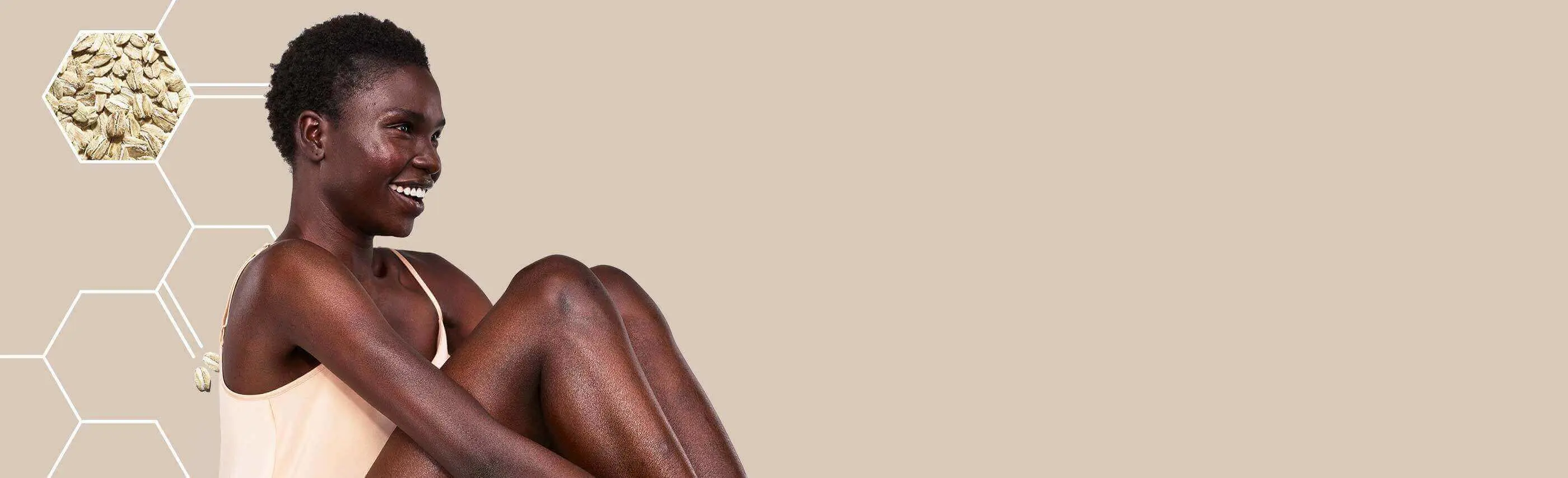 modelo da aveeno a sorrir e a olhar para baixo com uma pele brilhante
