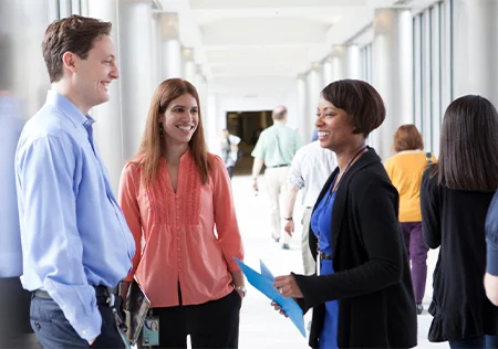 People standing and talking in office hallway