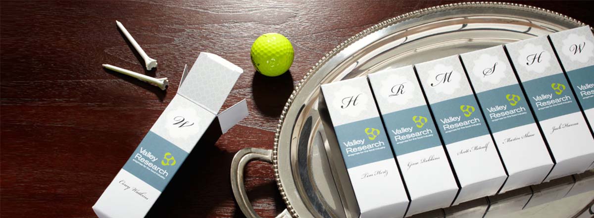 Custom printed boxes on a silver platter, with golf tees and golf ball 