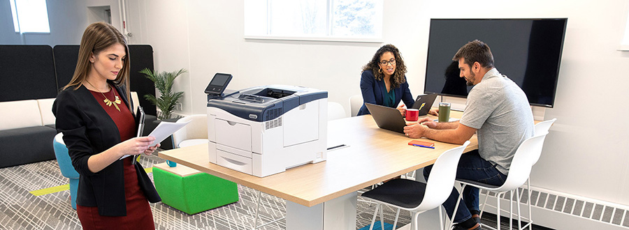 3 professionals at a table with a Xerox printer