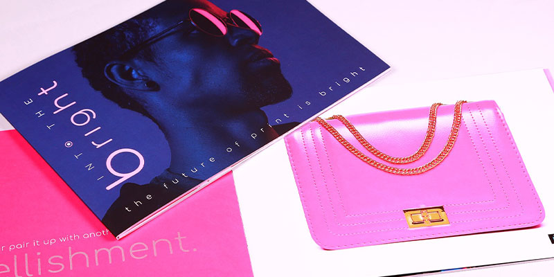 Pink Purse with blue and pink magazines. 