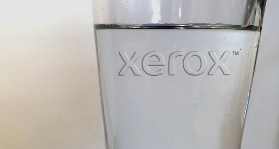 Pint glass with the Xerox logo embossed on the side