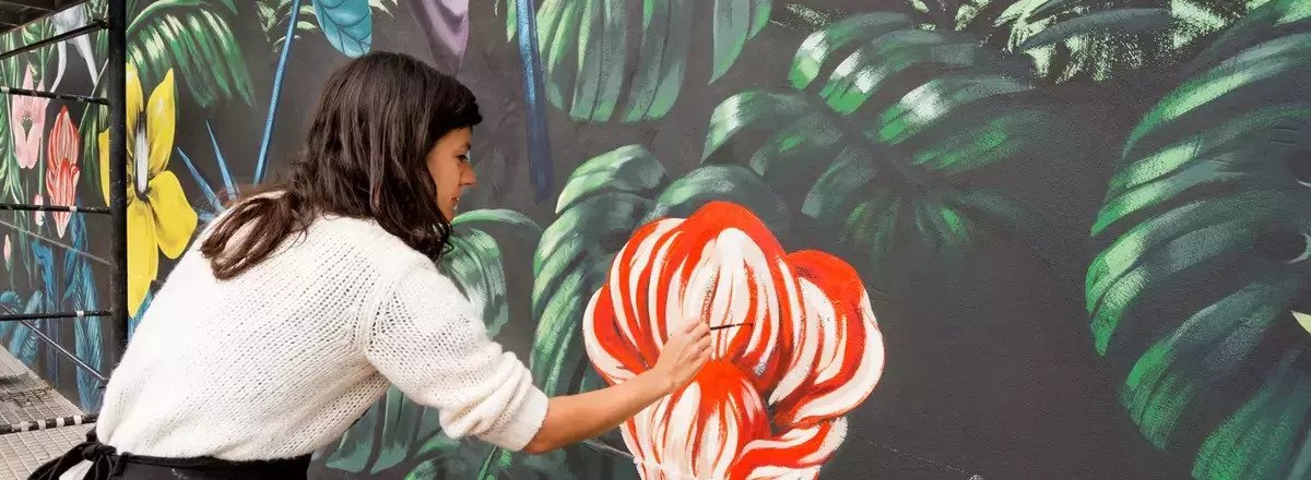 woman painting flower mural