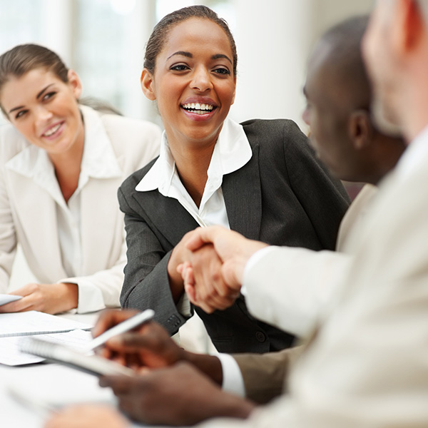 A businesswoman shaking hands with someone at a table