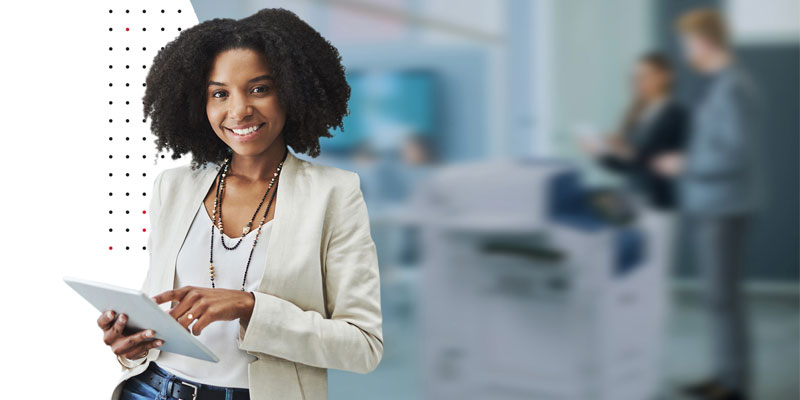 woman holding tablet with blurred office view in background