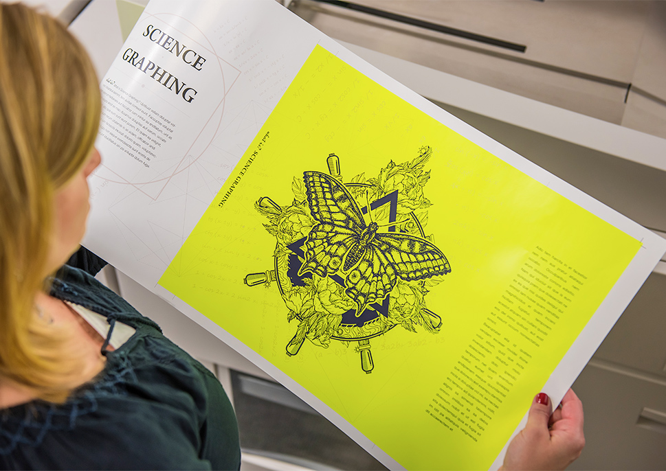 Woman holding fluorescent yellow print sample with a line drawing of a butterfly
