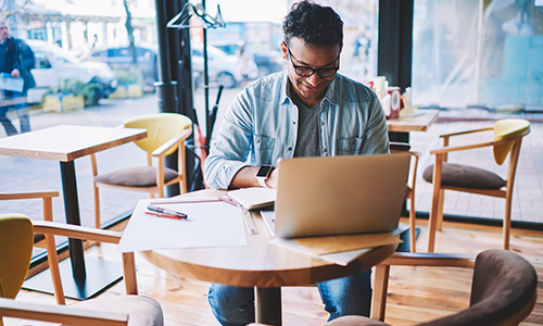 Man using a laptop in a coffee shop