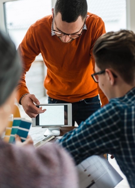 Man showing coworkers data on a smartphone