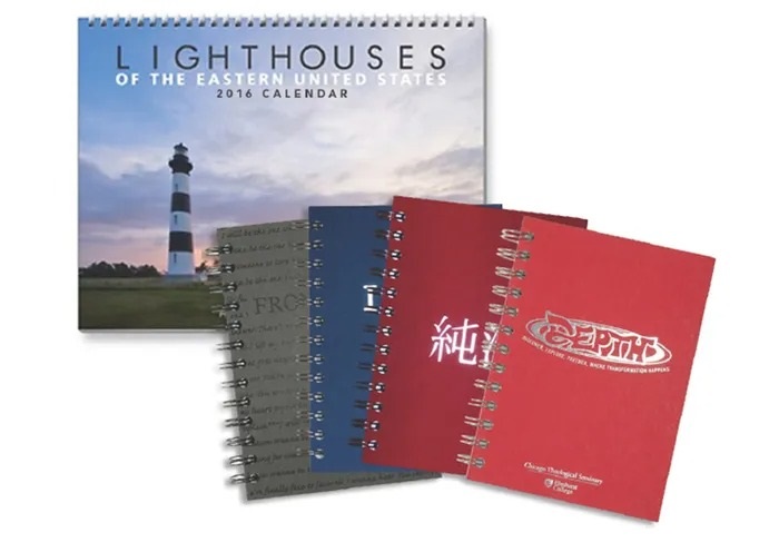 Wire bound print samples including a calendar with pictures of lighthouses and a stack of 4 wire bound notebooks