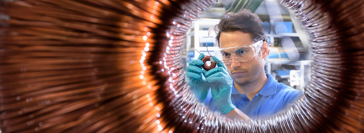 View of a scientist with goggles through a ring of coiled wires