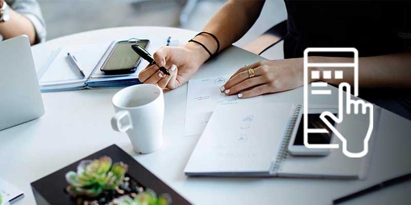 Meeting table with laptop, coffee, smartphones, and notebooks, overlaid with an icon of a hand touching a smartphone