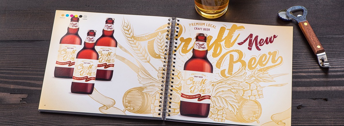 A spiral bound book on a wooden table with color photos of craft beer