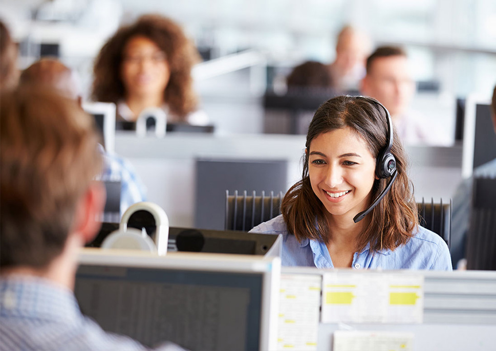 A smiling customer service representative in a call center
