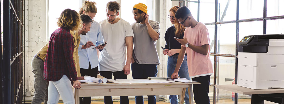 group of people standing over a table working on a project