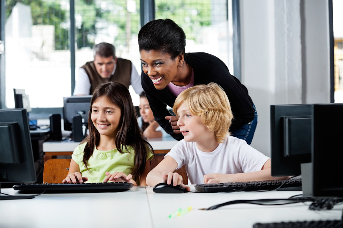 Children sitting at table with teacher