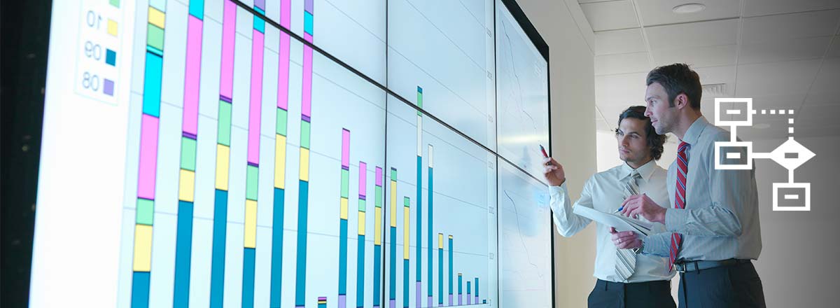 Two men looking at charts on a light-up board