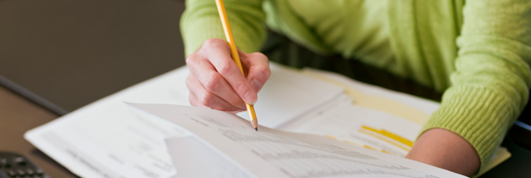 Writing with a pencil on a printed report