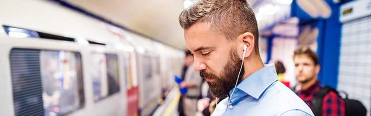 man in subway station with headphones on