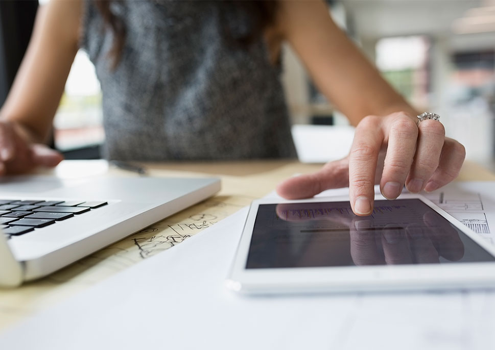 Businesswoman using laptop and tablet