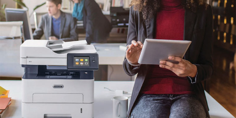 ConnectKey feature woman holding tablet next to printer
