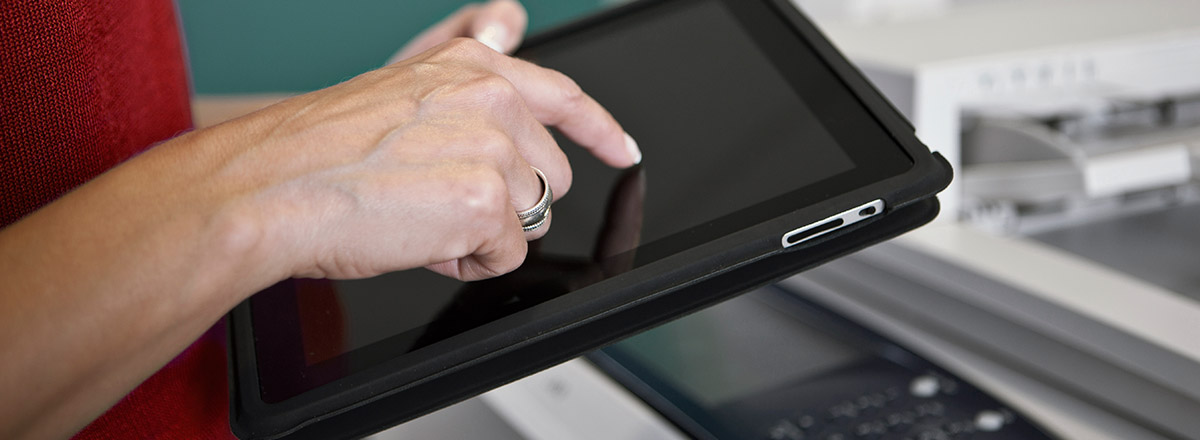 Finger touching the screen of a large tablet