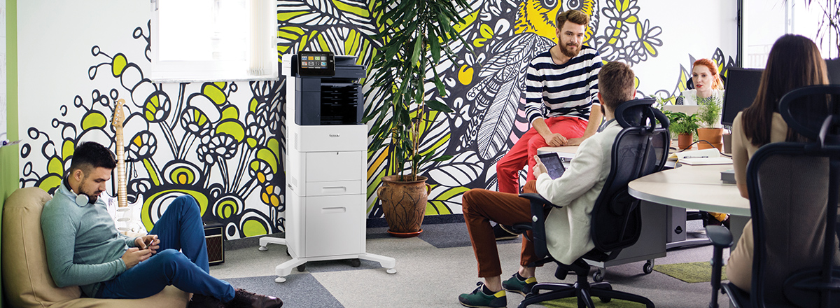 Young people in a modern office, with a Xerox MFP, and a mural with leaves and bees