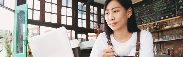 Woman in coffee shop working on laptop