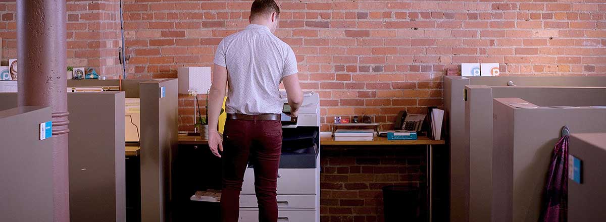 Office with a man using a Xerox AltaLink C8000 Series MFP