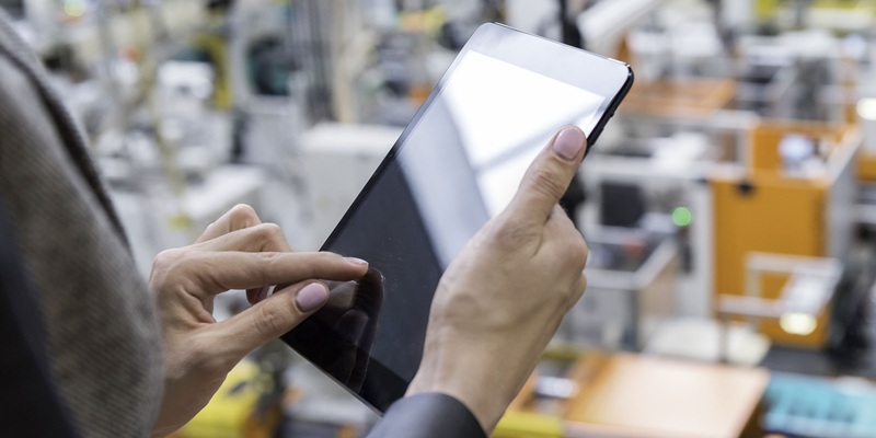 woman working on a tablet in a manufacturing environment